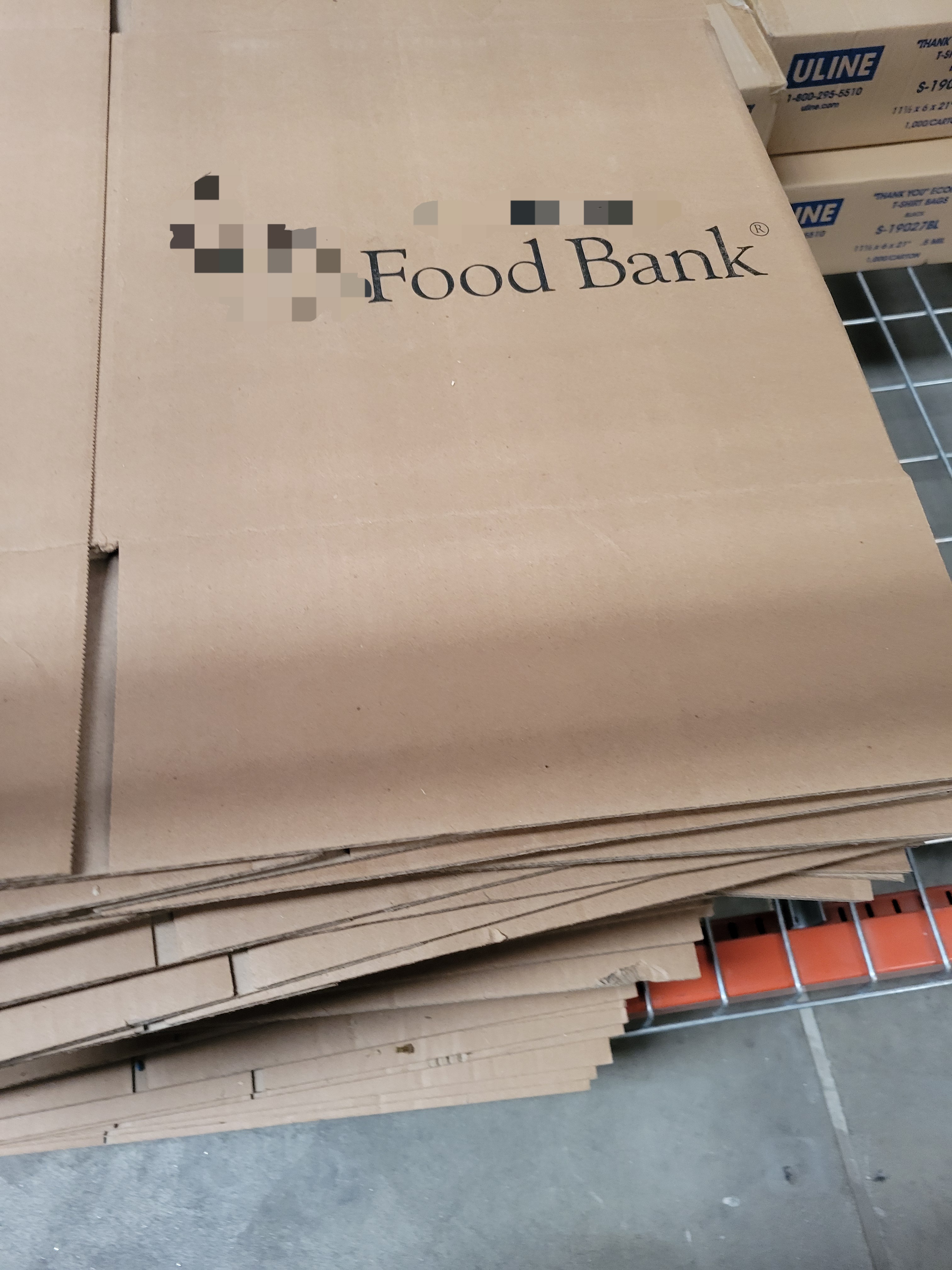 Stack of cardboard boxes with the words food bank printed on them.